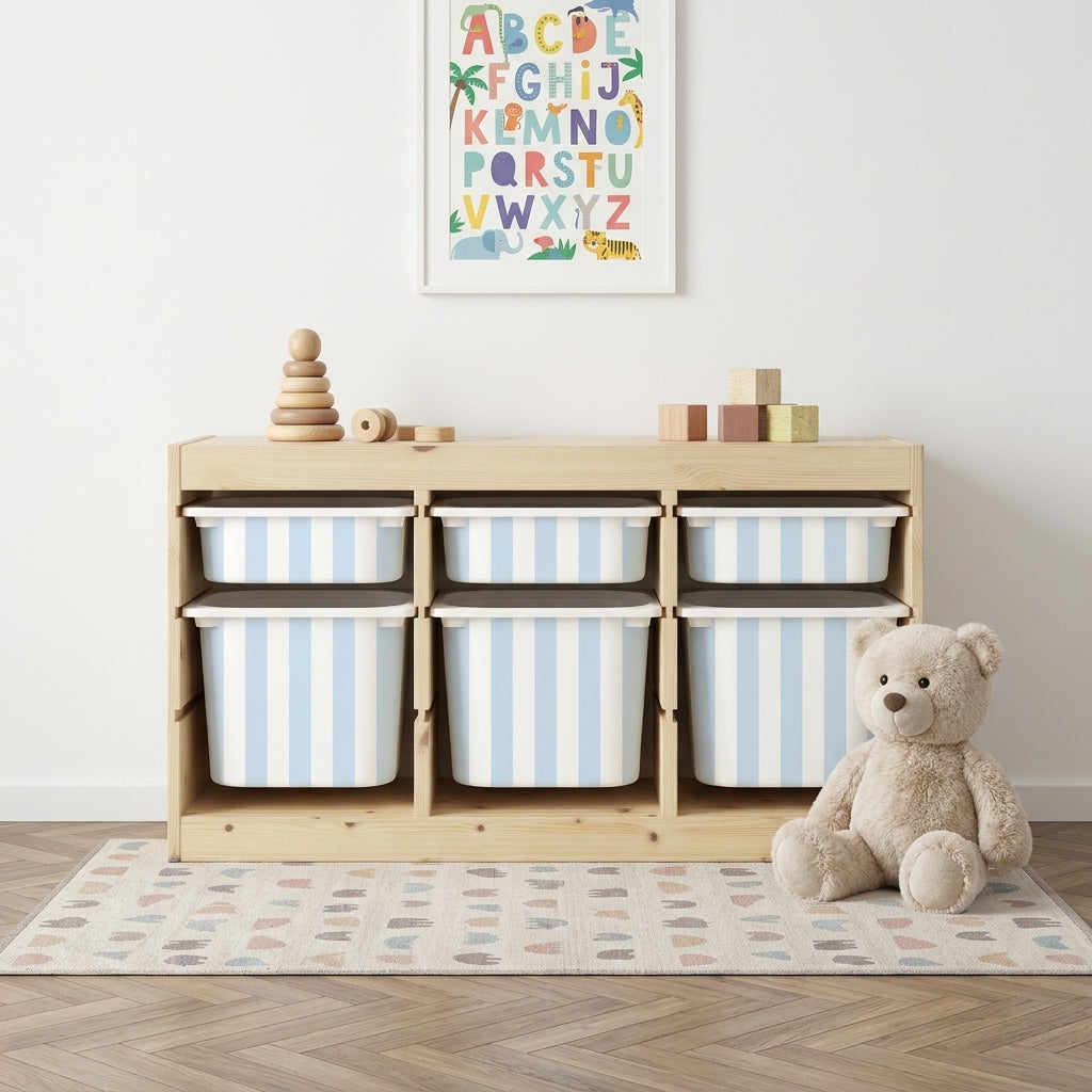 Sinise ja valge triibuga Mello kleebised IKEA TROFAST hoiukastidel puidust riiulis, otsevaade kaisukaruga lastetoas.
