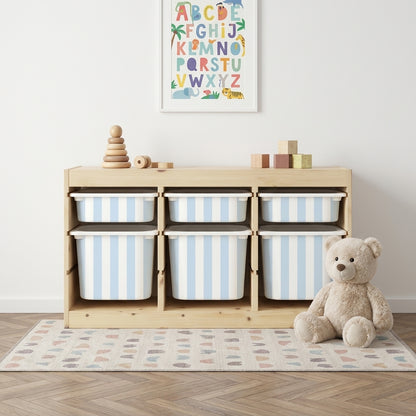 Sinise ja valge triibuga Mello kleebised IKEA TROFAST hoiukastidel puidust riiulis, otsevaade kaisukaruga lastetoas.